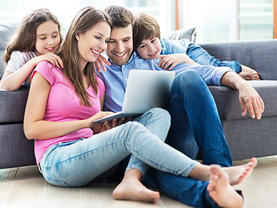 Jeune famille heureuse sur un ordinateur